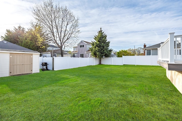view of yard featuring an outbuilding, a shed, a residential view, and a fenced backyard