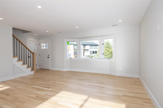 unfurnished living room with light wood finished floors, stairs, visible vents, and recessed lighting