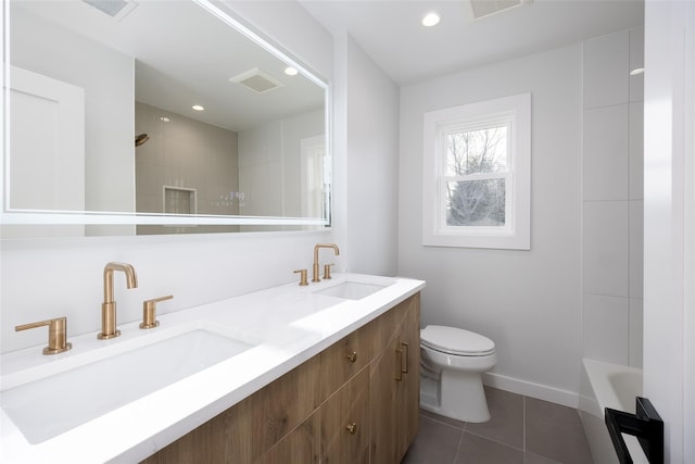 bathroom featuring a tile shower, toilet, tile patterned flooring, and a sink