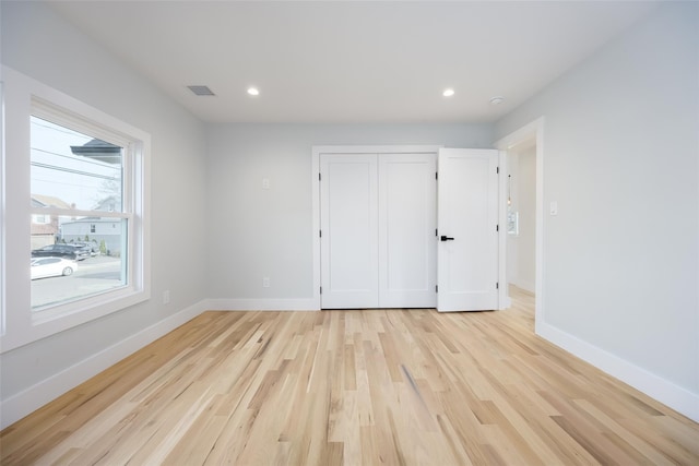 spare room featuring baseboards, visible vents, light wood-style flooring, and recessed lighting