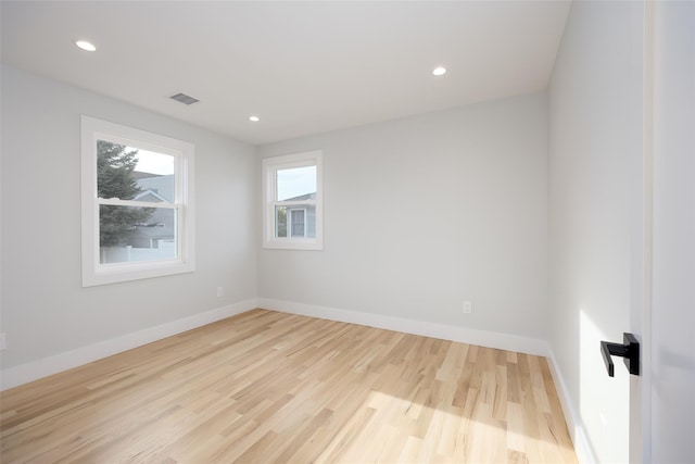 empty room with baseboards, recessed lighting, wood finished floors, and visible vents