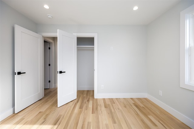 unfurnished bedroom featuring baseboards, light wood-type flooring, a closet, and recessed lighting