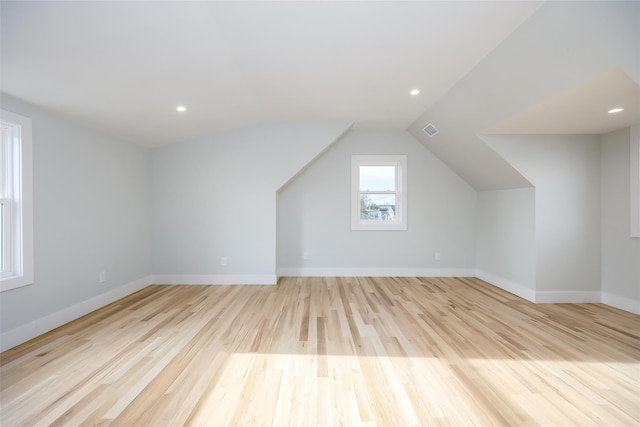 additional living space featuring baseboards, visible vents, lofted ceiling, and light wood finished floors