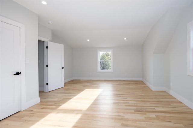 interior space with lofted ceiling, recessed lighting, light wood finished floors, and baseboards