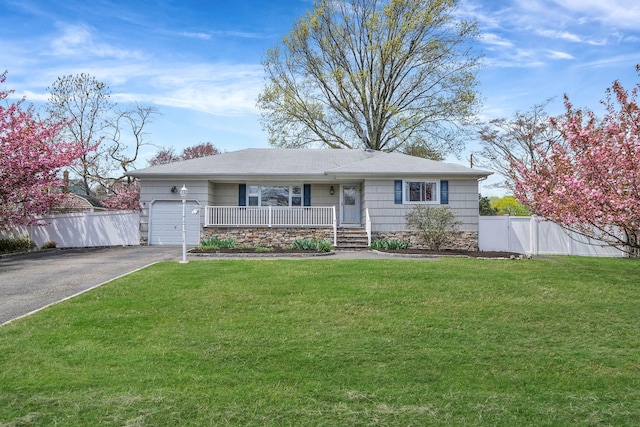 single story home featuring a porch, fence, a garage, driveway, and a front yard