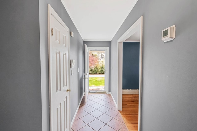 doorway featuring baseboards, light tile patterned floors, crown molding, and a baseboard radiator