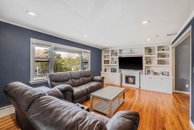 living room featuring visible vents, a warm lit fireplace, crown molding, and recessed lighting