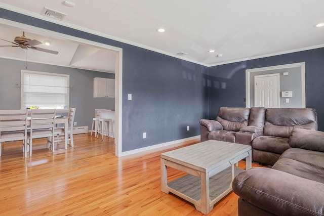 living area featuring ornamental molding, a ceiling fan, visible vents, and light wood-style flooring