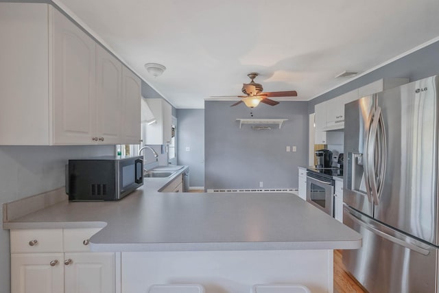 kitchen featuring appliances with stainless steel finishes, ceiling fan, white cabinets, and a sink