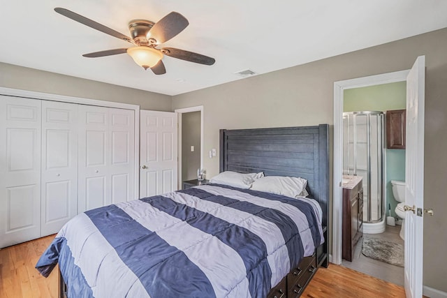 bedroom featuring connected bathroom, light wood-style floors, a closet, visible vents, and a ceiling fan