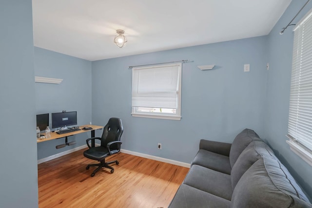 office area with a wealth of natural light, wood finished floors, and baseboards