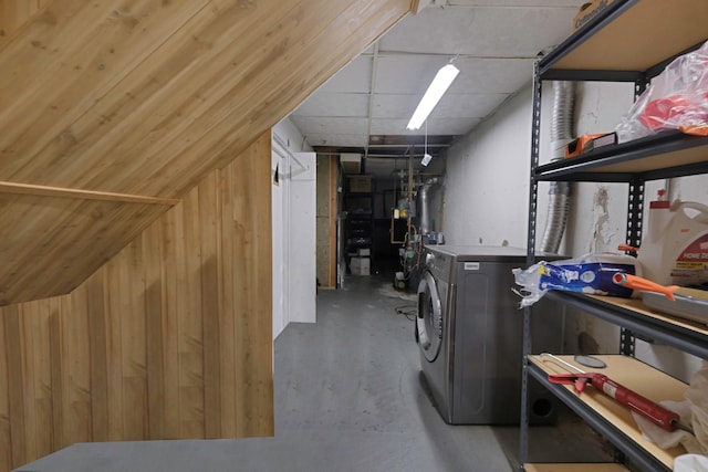 washroom featuring washer and dryer, wood walls, and laundry area