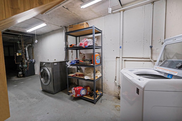 clothes washing area featuring washer and dryer, laundry area, and a heating unit