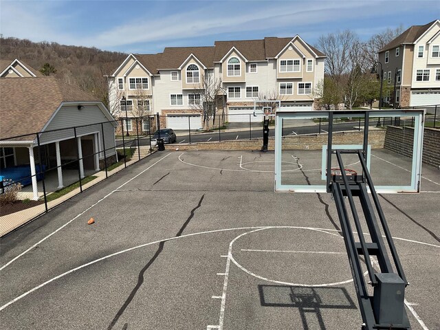 view of sport court featuring fence, community basketball court, and a residential view