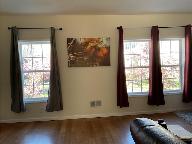 interior space with visible vents, baseboards, and wood finished floors