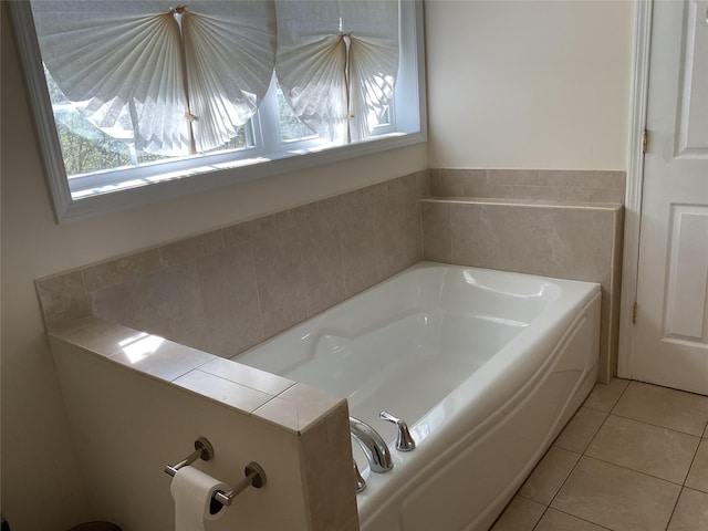 bathroom with tile patterned floors and a bath