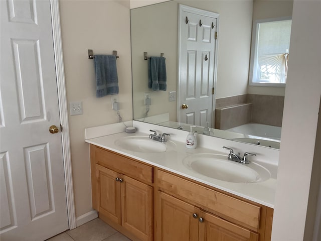 bathroom with double vanity, tile patterned floors, a sink, and a garden tub