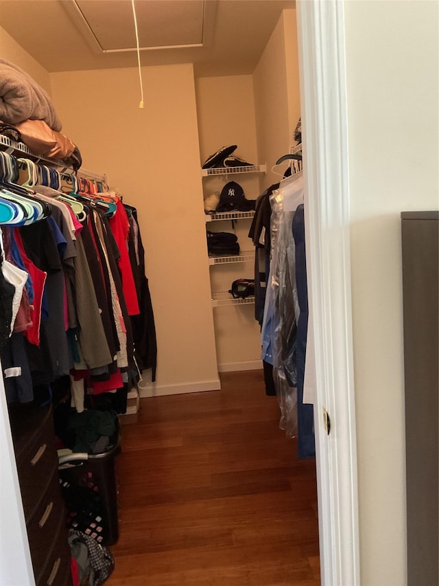 walk in closet featuring wood finished floors and attic access