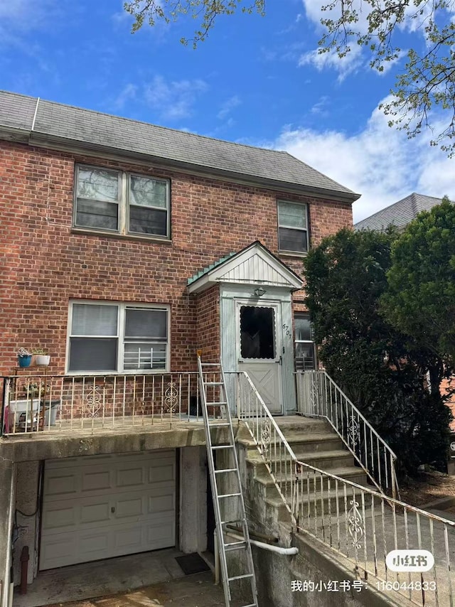 townhome / multi-family property with an attached garage, a shingled roof, and brick siding