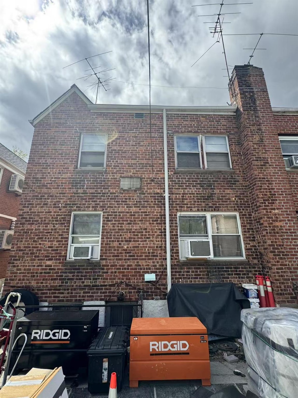 view of front facade with cooling unit and brick siding