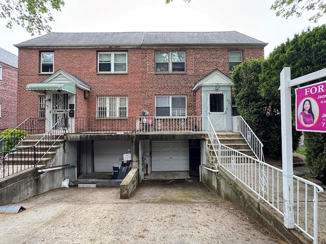 67-07 Fresh Meadow Ln, Fresh Meadows, NY 11365 - multi unit property featuring concrete driveway, an attached garage, a shingled roof, and brick siding