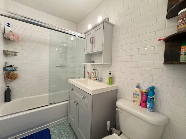 67-07 Fresh Meadow Ln, Fresh Meadows, NY 11365 - full bath with toilet, tile walls, vanity, tile patterned flooring, and bath / shower combo with glass door