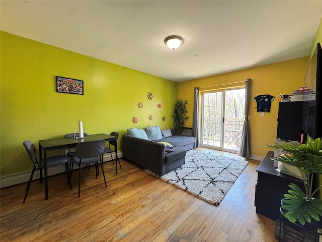 living room featuring a baseboard radiator, wood finished floors, and baseboards