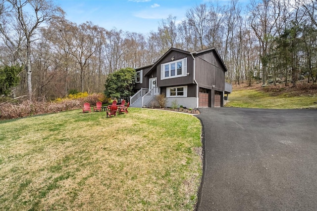 split foyer home featuring a garage, driveway, and a front yard