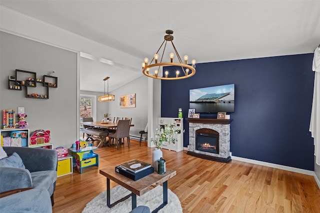 living area featuring wood finished floors, a chandelier, a baseboard heating unit, baseboards, and lofted ceiling