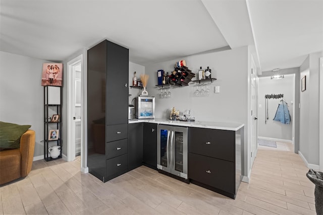 bar with light wood-style floors, indoor bar, and wine cooler