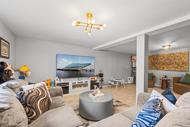living room featuring a chandelier, wood finished floors, and a glass covered fireplace