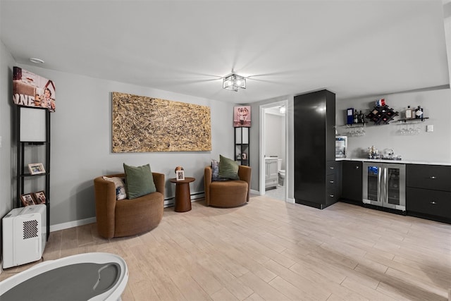 living area with baseboards, a dry bar, light wood-style floors, and wine cooler