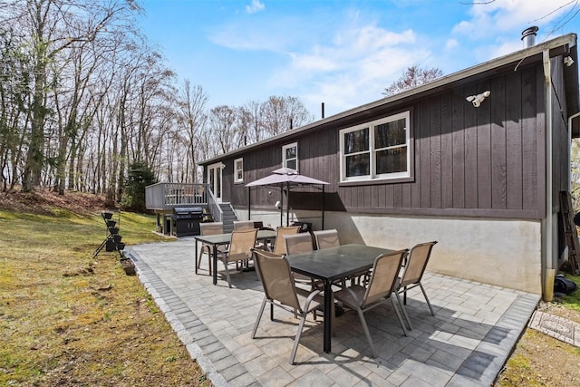 view of patio featuring a deck, outdoor dining area, and a grill