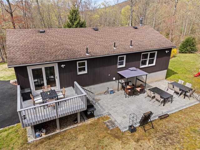 back of property with a patio area, outdoor dining space, roof with shingles, an outdoor hangout area, and a deck
