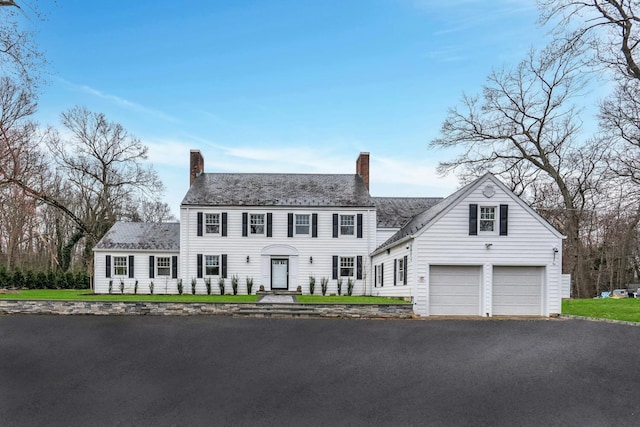 539 Split Rock Rd, Syosset, NY 11791 - colonial-style house with a garage, a chimney, and driveway