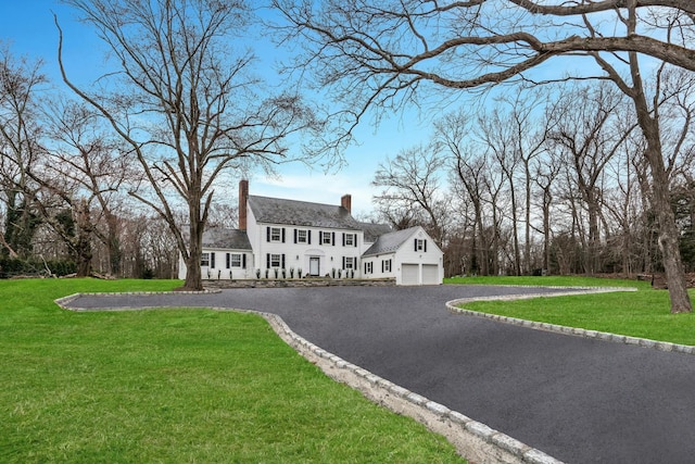 539 Split Rock Rd, Syosset, NY 11791 - colonial-style house with an attached garage, a chimney, aphalt driveway, and a front yard