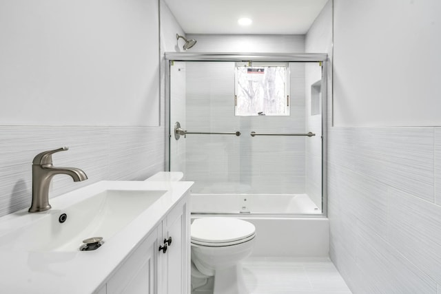 539 Split Rock Rd, Syosset, NY 11791 - bathroom featuring vanity, combined bath / shower with glass door, toilet, and tile walls