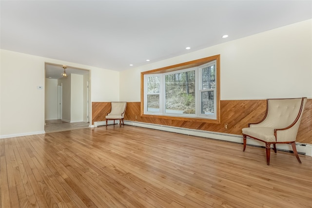 unfurnished room with light wood-type flooring, a baseboard radiator, and recessed lighting