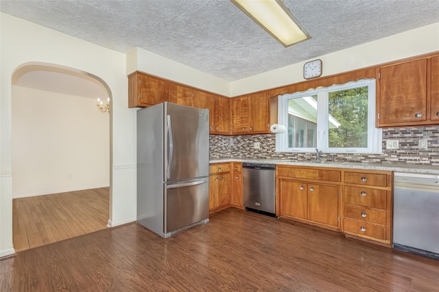 kitchen featuring light countertops, dark wood-style flooring, appliances with stainless steel finishes, and a sink