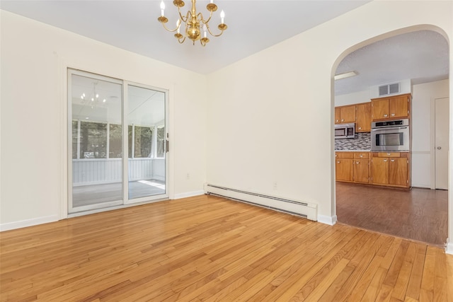 interior space with a notable chandelier, baseboard heating, arched walkways, light wood-style flooring, and visible vents