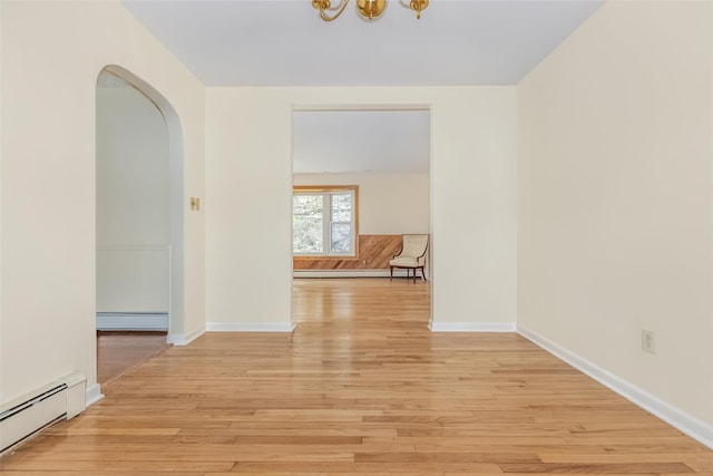 hallway featuring baseboards, a baseboard radiator, and light wood-style flooring