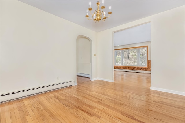 spare room featuring arched walkways, light wood-style floors, a notable chandelier, and a baseboard radiator