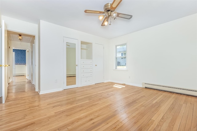 unfurnished bedroom featuring a baseboard radiator, attic access, baseboards, light wood-type flooring, and a baseboard heating unit