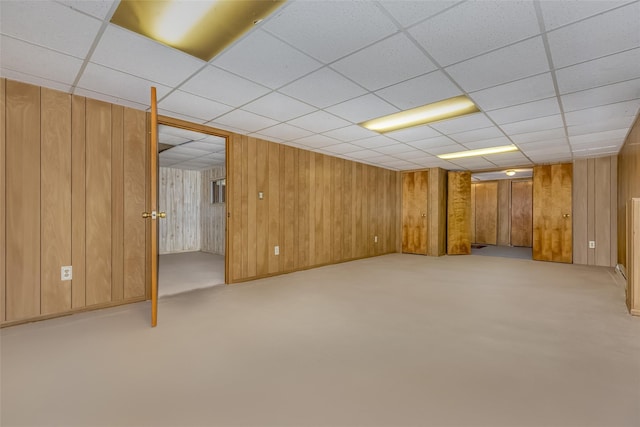 finished below grade area with wooden walls and a paneled ceiling
