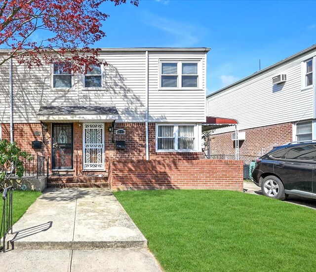 view of front of home featuring a front lawn and brick siding