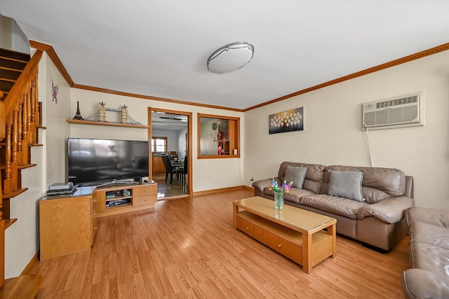living area with ornamental molding, an AC wall unit, stairs, and light wood-style floors