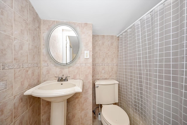 bathroom with tile walls and toilet