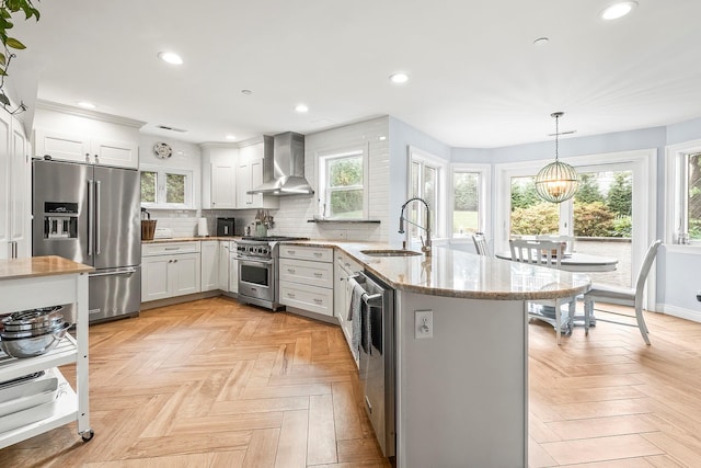 126 Lincoln Ave E, West Harrison, NY 10604 - kitchen featuring a sink, premium appliances, wall chimney exhaust hood, a peninsula, and backsplash