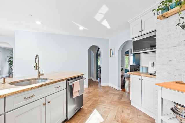 126 Lincoln Ave E, West Harrison, NY 10604 - kitchen featuring arched walkways, butcher block countertops, appliances with stainless steel finishes, a sink, and white cabinetry