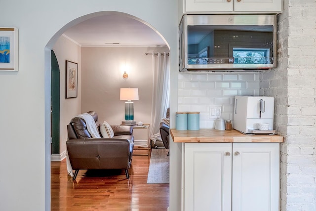 126 Lincoln Ave E, West Harrison, NY 10604 - sitting room with wood finished floors, crown molding, baseboards, and arched walkways